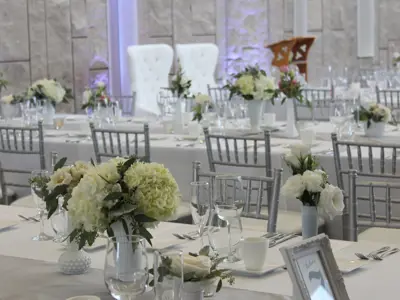 rows of white tables set for wedding dinner