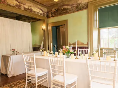 long table set for dinner with white tablecloth, flowers and candles