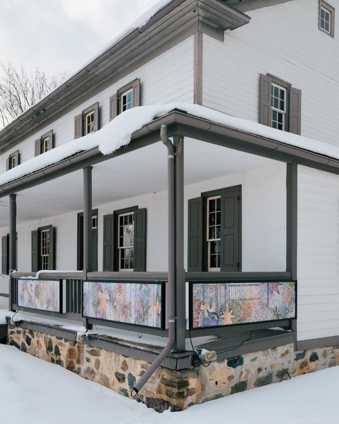 Side view of Schneider Haus porch showing art in lightboxes hung on the front