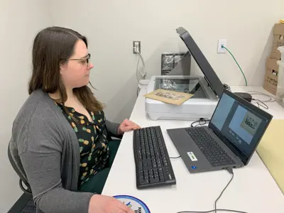 Side view of woman using computer and image scanner