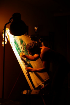 Damola Disu painting on a large canvas